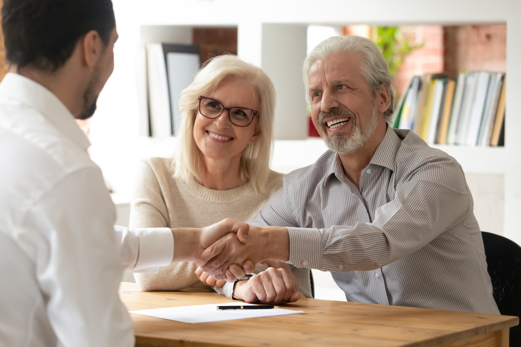 A Man And Woman Shake Hands With An Older Man